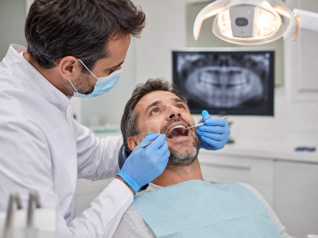 Implant dentist in Gurugram checking patient smile